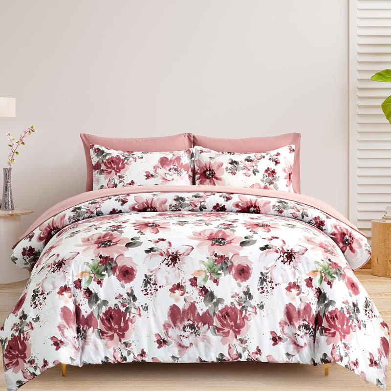 A bedding set with a floral design, featuring pink and white flowers, presented in a bedroom setting.