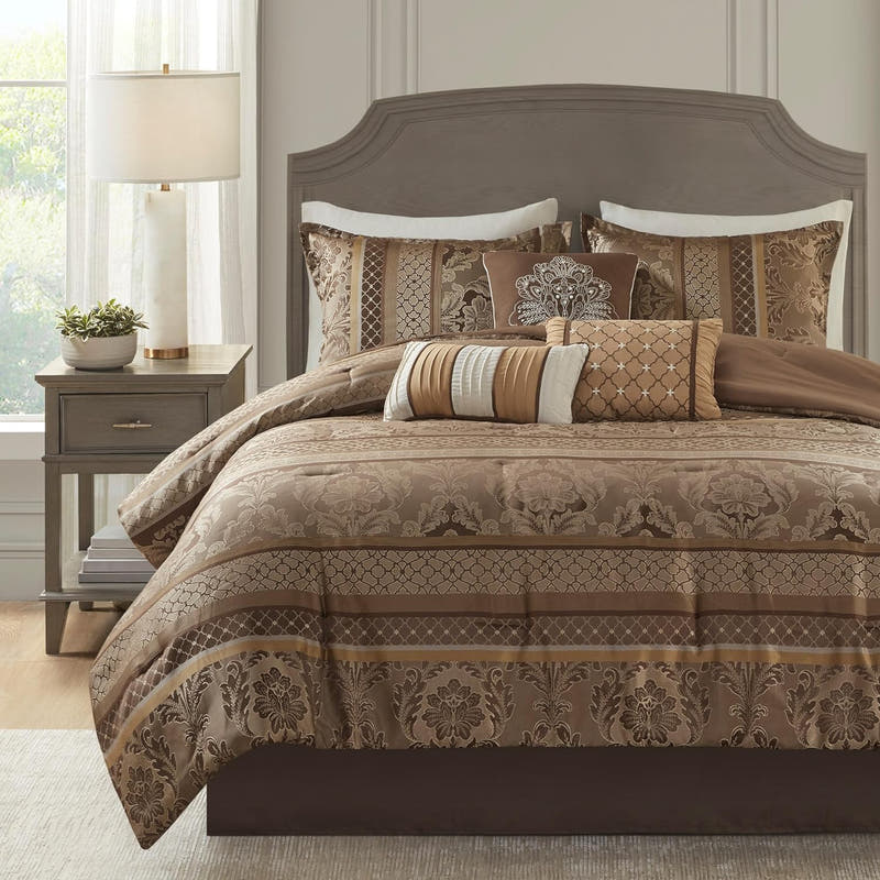 A luxurious bed in a bag set with jacquard design, including a comforter, bed skirt, shams, and decorative pillows, displayed in a bedroom setting.