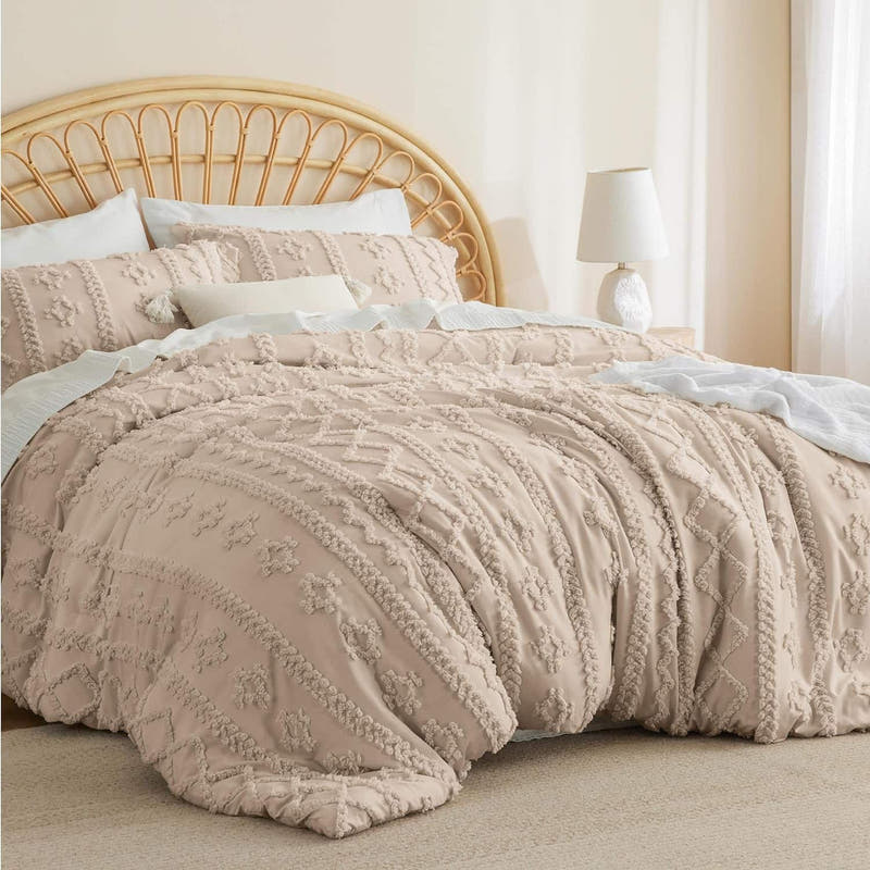 Beige textured comforter on a bed with a wooden headboard and white pillows.