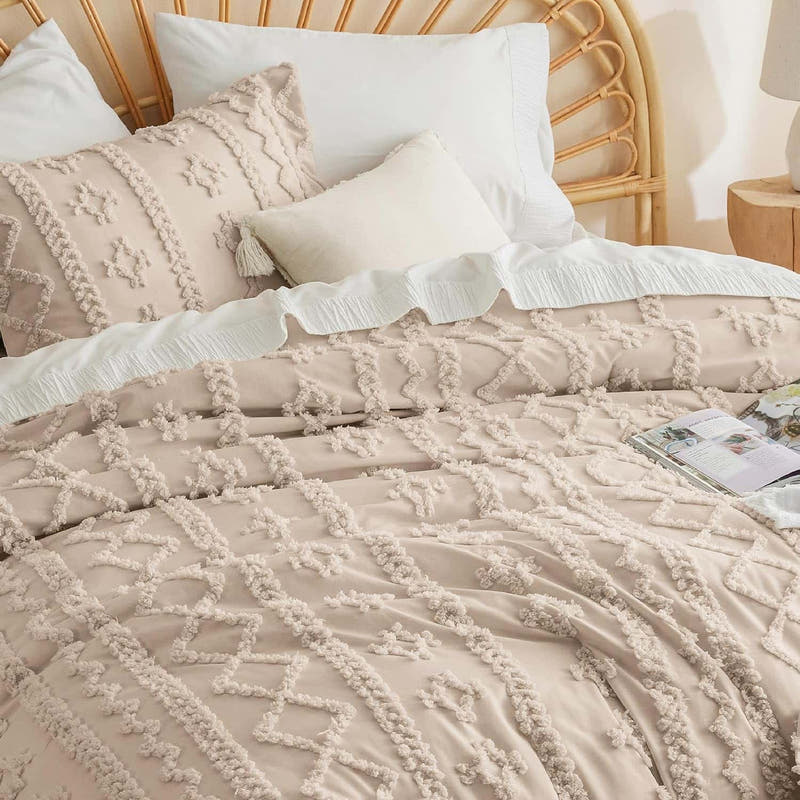 Neatly made bed with textured bedding and decorative pillows in a bedroom setting.