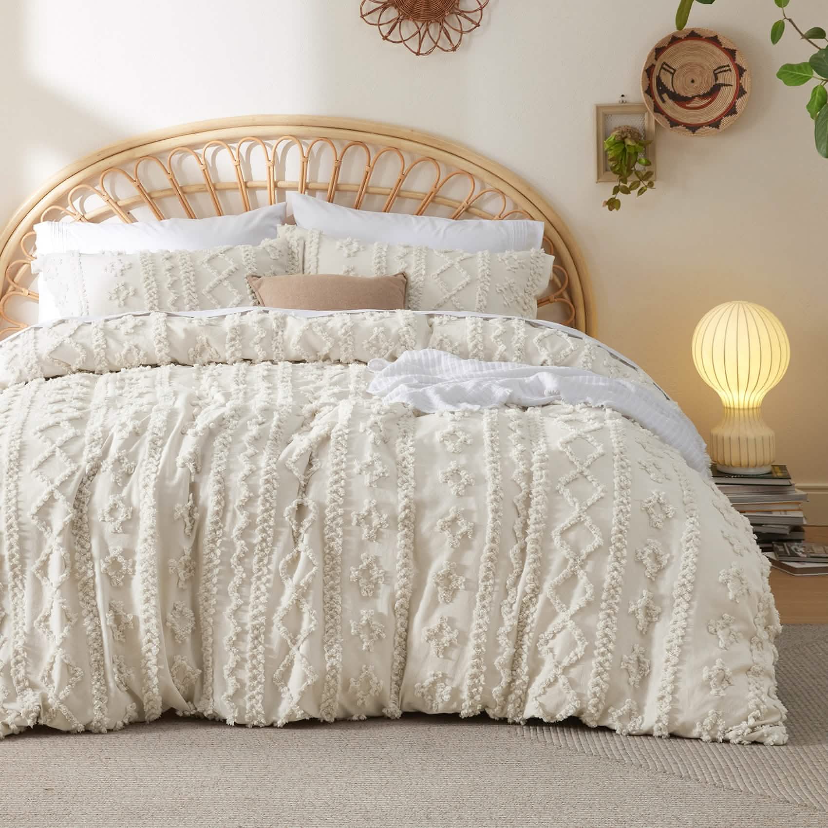 Neatly made bed with white boho textured bedding in a bedroom setting.